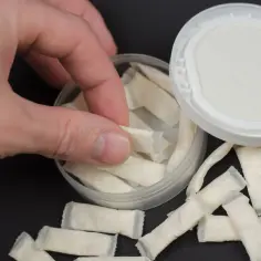 Dłoń sięga po białe saszetki. To snus, co to jest? Bez dymu, tylko nikotyna.