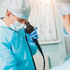 Lekarz w masce i rękawiczkach przygotowuje się do cystoskopii. Ile dni w szpitalu po zabiegu?