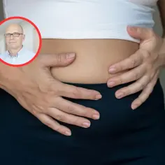 Lekarz w okręgu wskazuje na brzuch kobiety, sugerując problemy z jelitami.
