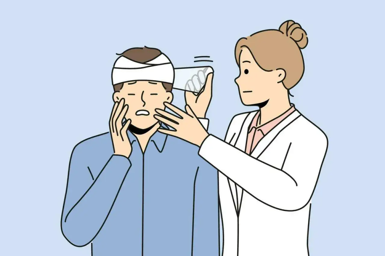 Lekarz bada pacjenta z opatrunkiem na głowie. To przykład, jak wygląda traumatologia.