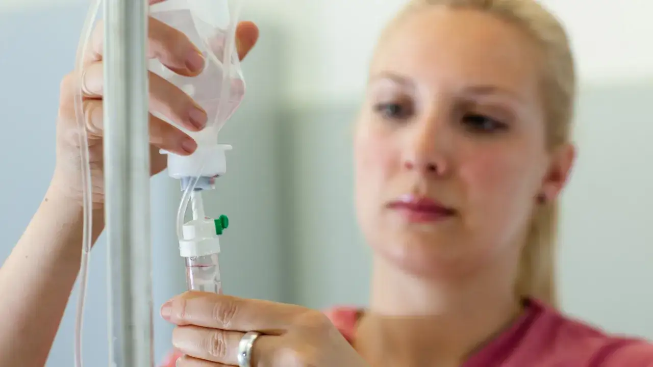 Pielęgniarka przygotowuje kroplówkę do leczenia biologicznego.